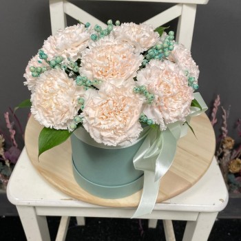 Composition of delicate dianthus in a hat box