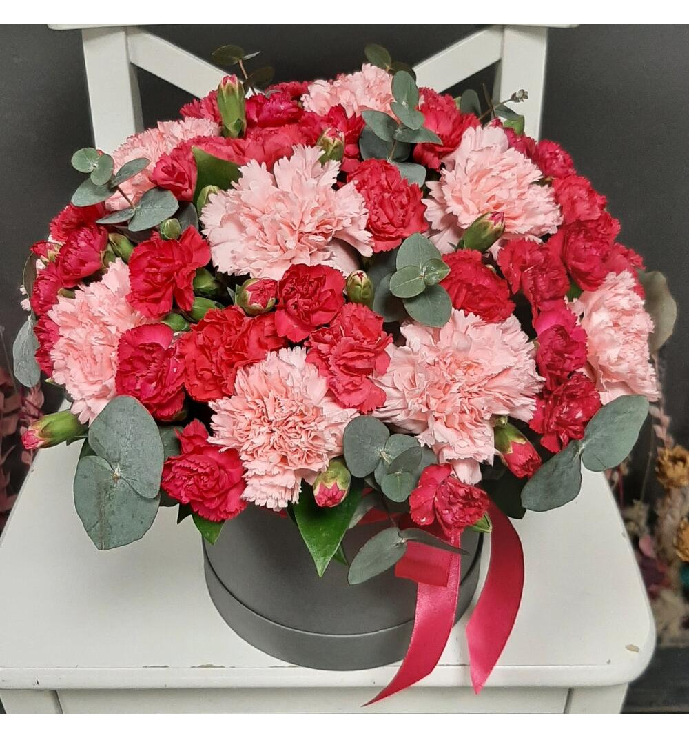 Яркая кустовая и нежно коралловая гвоздика в шляпной коробке